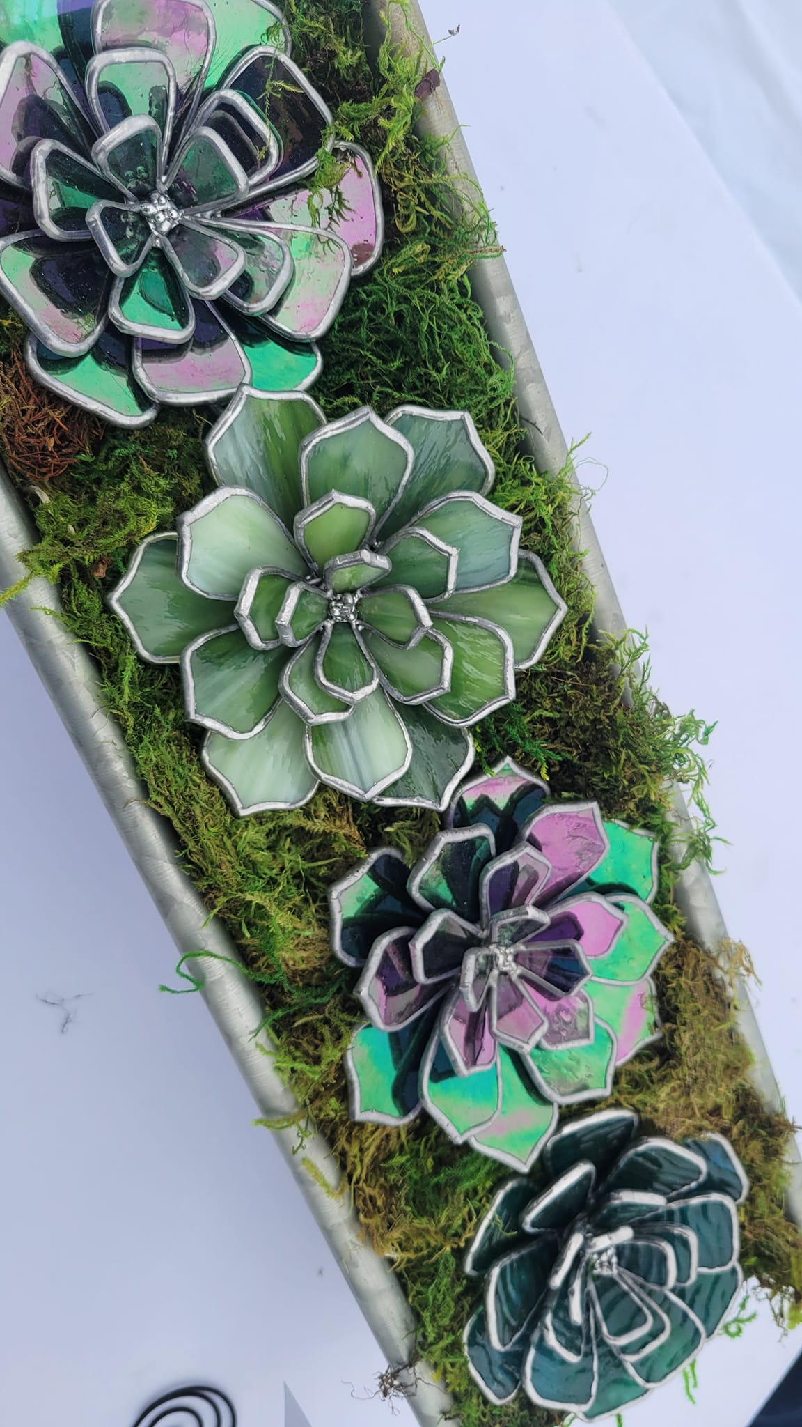 Four assorted stained glass succulents arranged in a decorative dish