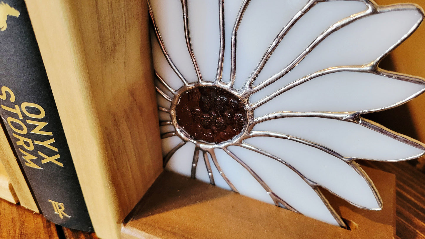 Close up of handmade stained glass daisy bookend showing solder lines and textured glass center